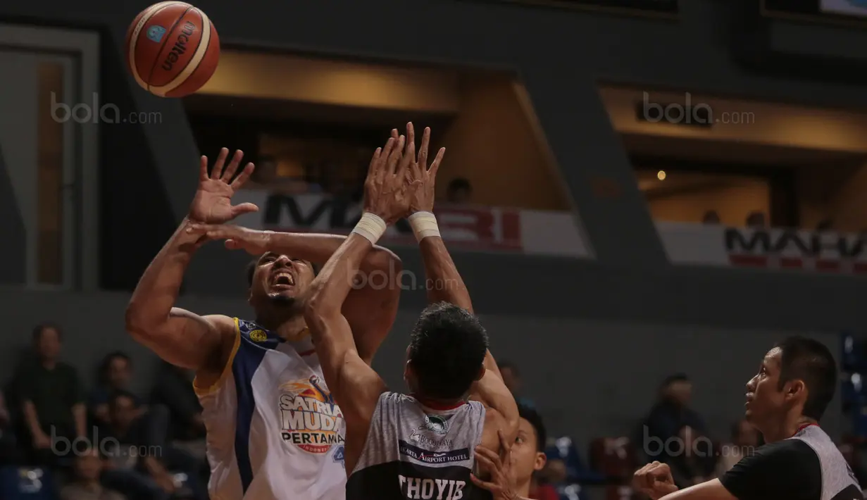 Pebasket Satria Muda, Alexandros Lowhorn (kiri) gagal memasukan bola saat diadang pemain Aspac Jakarta, Thoyib Isman pada laga Perbasi Cup 2017 di Sports Mall, Kelapa Gading, Jakarta, (09/11/2017). Satria Muda menang 86-79. (Bola.com/Nick Hanoatubun)