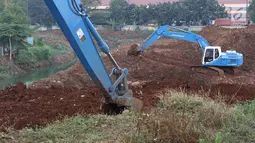 Alat berat mengeruk tanah di lokasi pembangunan Waduk Rambutan, Jakarta Timur, Rabu (24/10). Keberadaan waduk tersebut nantinya diharapkan bisa menahan luapan kali saat mendapat banjir kiriman. (Liputan6.com/Immanuel Antonius)