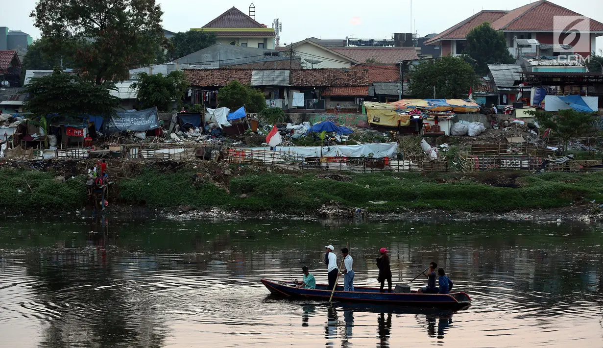 Sejumlah remaja menaiki sampan di areal proyek pengerukan lumpur di Kali Ciliwung, Kawasan Tanah Abang, Jakarta, Jum'at (22/9). (Liputan6.com/JohanTallo)