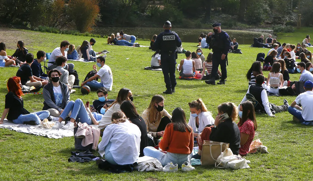 Polisi memeriksa orang-orang yang menikmati matahari di Taman Vauban, Lille, Prancis, Kamis (1/4/2021). Prancis bersiap melakukan lockdown setelah pemerintah menemukan adanya lonjakan kasus COVID-19. (AP Photo/Michel Spingler)
