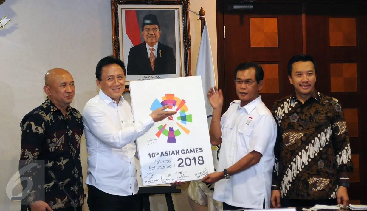 Kepala Barekraf, Triawan Munaf (kedua kiri) menyerahkan logo baru Asian Games 2018 kepada Wakil Ketua Umum KOI Muddai Maddang usai diperkenalkan di Kantor KSP Jakarta, Kamis (28/7). Logo bertema The Energy of Asia. (Liputan6.com/Helmi Fithriansyah)