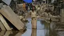 Kementerian Kesehatan sudah mengeluarkan peringatan adanya potensi lonjakan dua penyakit pasca bencana banjir bandang dan tanah longsor di Aceh, yaitu Demam Berdarah Dengue (DBD) dan Leptospirosis. Tampak dalam foto, seorang perempuan berlumuran lumpur berdiri di jalanan yang dipenuhi lumpur setelah banjir bandang melanda daerah tersebut di Aceh Tamiang, Provinsi Aceh, pada Sabtu 6 Desember 2025. (YT HARIONO/AFP)