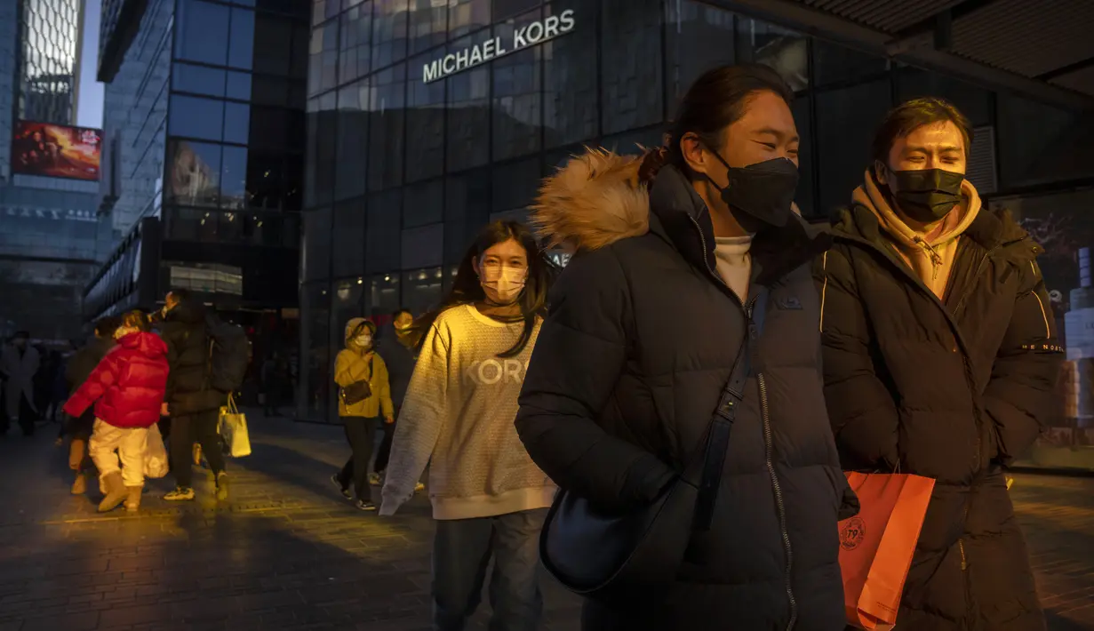 Pengunjung diterangi oleh pantulan sinar matahari saat mereka berjalan melalui pusat perbelanjaan pada hari terakhir minggu liburan Tahun Baru Imlek di Beijing, Jumat, 27 Januari 2023. (AP Photo/Mark Schiefelbein)