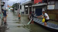 Sejumlah warga terpaksa menyewa sampan untuk bisa melintasi Jalan Cigebar yang terendam banjir, Kecamatan Bojongsoang, Bandung, Selasa, 19 April 2022. (Liputan6.com/Dikdik Ripaldi)