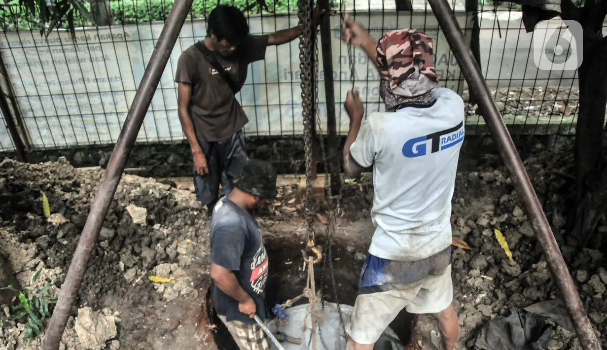 Pekerja menyelesaikan pembangunan sumur resapan di RPTRA Meruya Utara, Jakarta, Selasa (25/1/2022). Pembangunan 100 titik sumur resapan ini bertujuan untuk mengantisipasi banjir yang kerap terjadi di wilayah tersebut. (merdeka.com/Iqbal S. Nugroho)