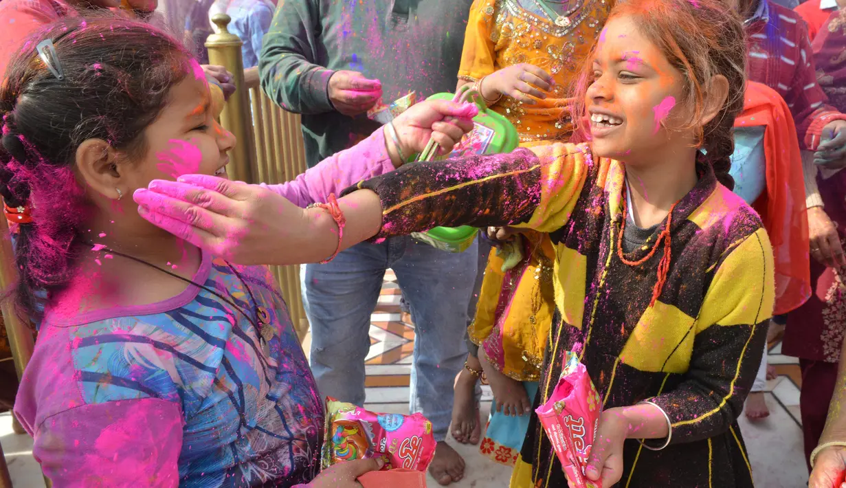 Anak-anak umat Hindu bermain dengan bubuk berwarna ketika merayakan festival keagamaan Holi di Kuil Swupramayan Kalupur, Ahmedabad, Rabu (20/3). Walaupun Holi merupakan festival Hindu, namun seluruh penduduk India merayakannya. (SAM PANTHAKY / AFP)