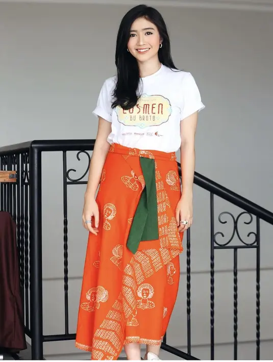 Kain warna oren motif ibu-ibu bersanggul dan motif batik juga dikenakan Febby dan dipadukan tshirt putihnya. [Instagram/@febbyrastanty]