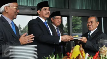 Ketua Mahkamah Agung Hatta Ali (tengah) memberikan potongan tumpeng ke hakim tertua di Mahkamah Agung seusai upacara peringatan HUT Mahkamah Agung ke-70 di Jakarta, Rabu (19/8/2015). (Liputan6.com/Herman Zakharia)