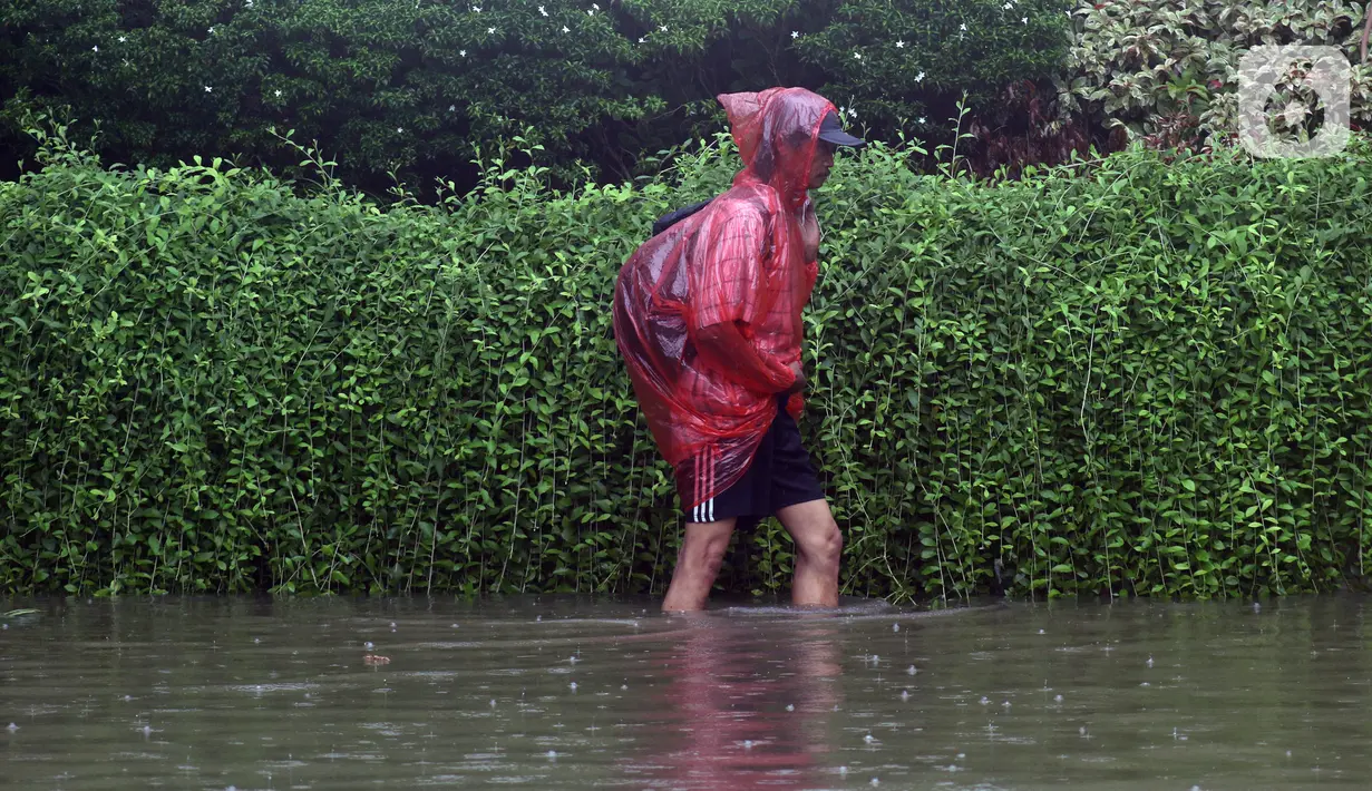 Warga melintasi Jalan Di Panjaitan dekat Halte Transjakarta Cawang Soetoyo yang banjir, Jakarta, Rabu (1/1/2020). Hujan yang mengguyur Jakarta sejak Selasa sore (31/12/2019) mengakibatkan banjir di sejumlah titik di Jakarta. (Liputan6.com/Helmi Fithriansyah)
