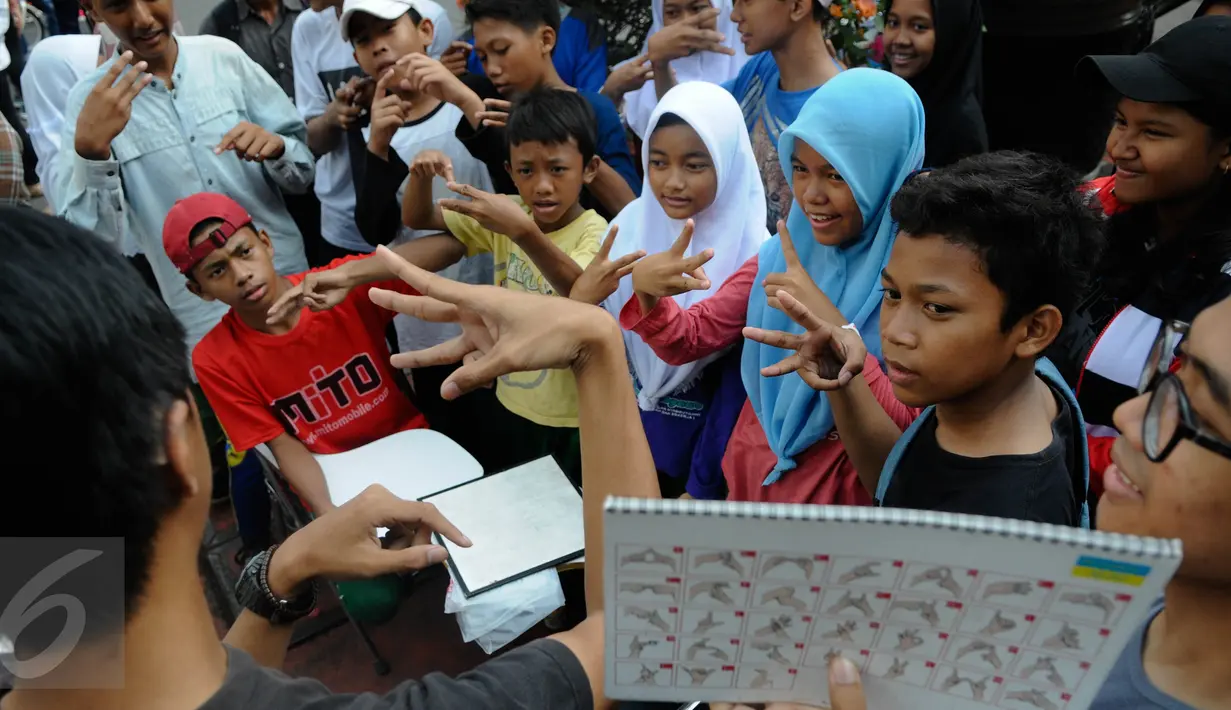 Anak-anak ikut berlatih bahasa isyarat saat sosialisasi di Car Free Day (CFD), Jakarta, Minggu (11/9). Sosialisasi belajar bahasa isyarat untuk mengkampanyekan penggunaan bahasa isyarat dalam dialog para penyandang tuna rungu. (Liputan6.com/Faizal Fanani)