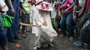 Seorang Eyo masqueraders muda menari saat memimpin kelompok mereka di Tafawa Balewa Square di Lagos, Nigeria (20/5). Festival ini pertama kali digelar pada tahun 1854, dan bertujuan untuk memperingati kehidupan Oba Akintoye. (AFP Photo/Stefan Heunis)