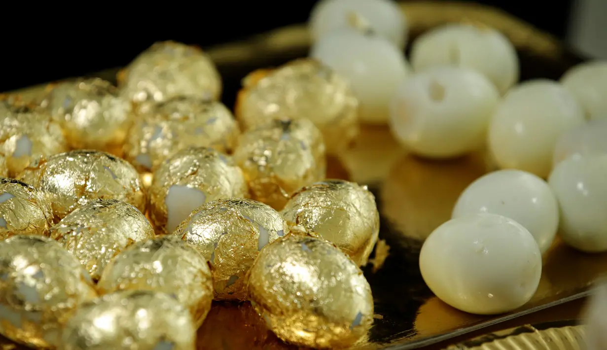 Lembaran emas tipis 24 karat menyelimuti telur rebus yang menjadi hidangan acara makan malam di Paris, Prancis, 28 Maret 2019. Makan malam tersebut disajikan oleh seniman Prancis, Frederique Lecerf. (REUTERS/Philippe Wojazer)