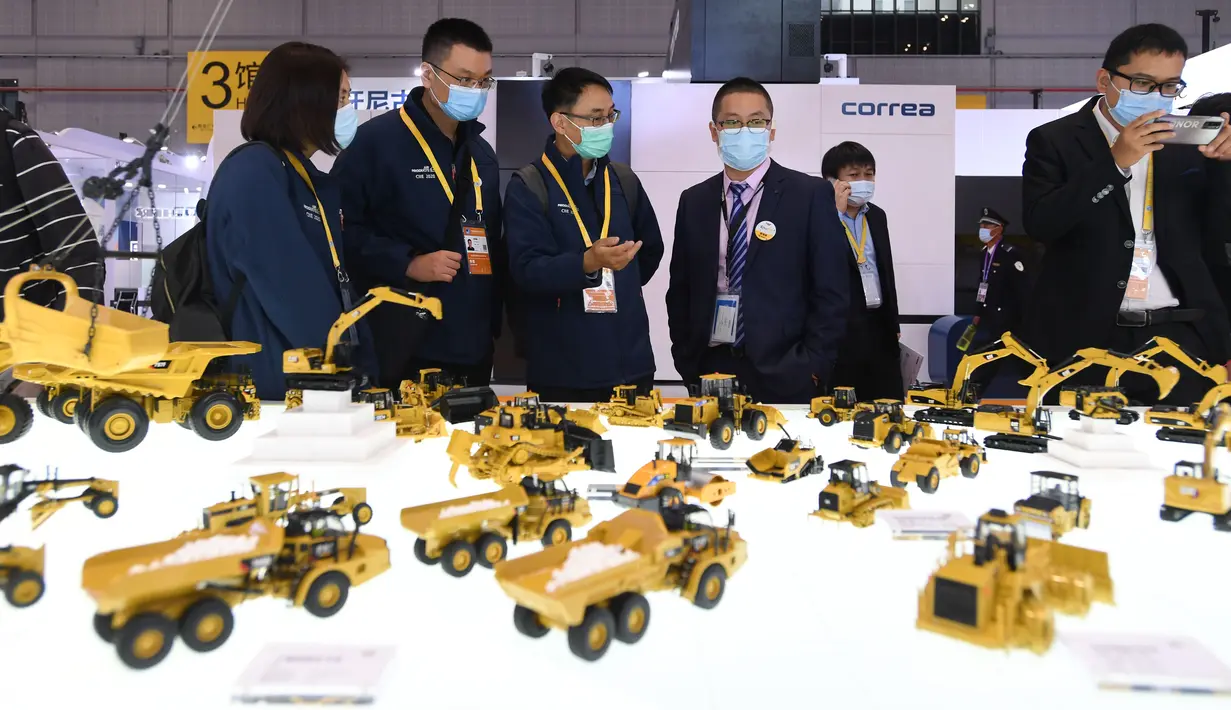 Para peserta pameran memperkenalkan kendaraan teknik di stan Caterpillar di area ekshibisi Peralatan dalam Pameran Impor Internasional China (China International Import Expo/CIIE) ketiga di Shanghai, China timur, pada 5 November 2020. (Xinhua/Li Renzi)
