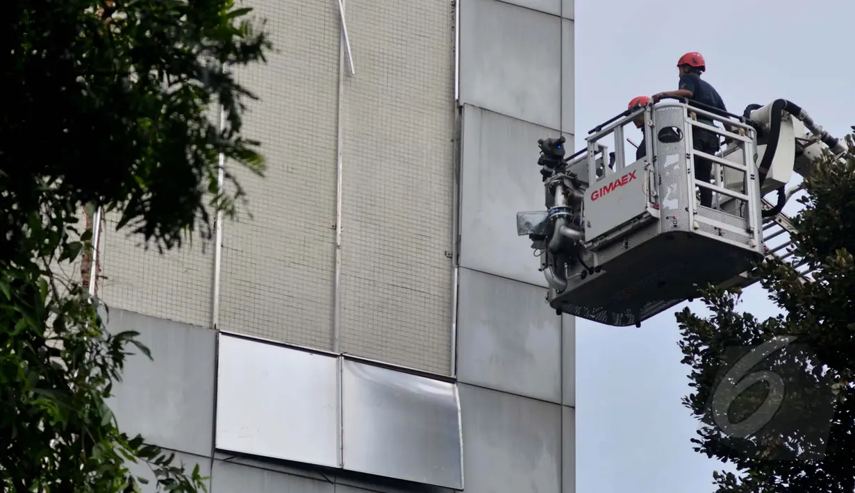 Petugas melepas plat aluminium pelapis dinding gedung Sekretariat Jenderal DPR RI yang roboh ditiup angin kencang di Kompleks Parlemen, Jakarta, Jumat (24/04/2015). Robohnya dinding karena usia gedung yang sudah lama. (Liputan6.com/Andrian M Tunay)