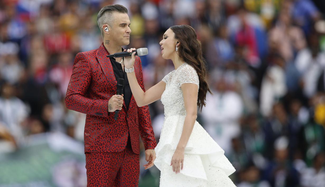 Penyanyi Rusia, Aida Garifullina, duet bersama penyanyi Inggris, Robbie Williams, saat pembukaan Piala Dunia di Stadion Luzhniki, Moskow, Kamis (14/6/2018). Laga pembuka Piala Dunia 2018 mempertemukan Rusia melawan Arab Saudi. (AP/Hassan Ammar)