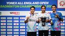 Peraih medali perak Anthony Sinisuka Ginting (kiri) dan peraih medali emas Jonatan Christie (kanan) merayakannya bersama pelatih mereka, Hendri Kurniawan Saputra di podium setelah bertanding di Final Tunggal Putra Kejuaraan Bulutangkis Terbuka All England di Utilita Arena, Birmingham, Inggris tengah, pada 17 Maret 2024. (JUSTIN TALLIS/AFP)