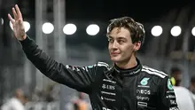 George Russell menyapa para penggemar usai memastikan diri menjadi yang tercepat dalam sesi kualifikasi F1 Singapura 2025 di Marina Bay Street Circuit, Singapura, Sabtu (4/10/2025). (AFP/Lillian SUWANRUMPHA)