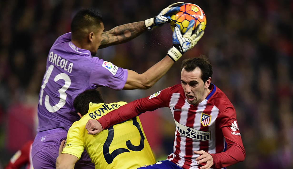 Kiper Villarreal, Alphonse Areola, duel udara dengan bek Atletico Madrid, Diego Godin, pada laga La Liga Spanyol di Stadion Vicente Calderon, Minggu (21/2/2016). Kedua tim bermain imbang 0-0. (AFP/Javier Soriano)
