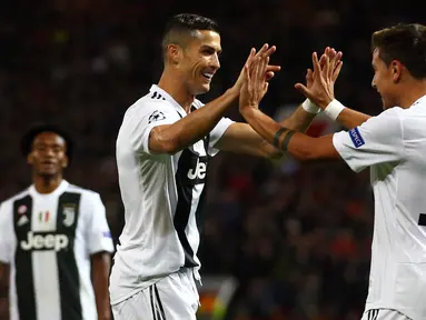 Penyerang Juventus, Paulo Dybala berselebrasi bersama Cristiano Ronaldo usai mencetak gol ke gawang Manchester United pada lanjutan grup H Liga Champions di Old Trafford, Inggris (23/10). Juventus menang tipis 1-0 atas MU. (AP Photo/Dave Thompson)