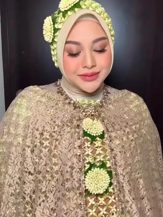 Wajahnya dipulas makeup flawless yang berfokus pada eyeshadow coklat, blush on coral, dan lipstik nuansa coral dengan sentuhan lip gloss yang membuat bibirnya terlihat lebih plumpy. [Instagram/andisyameutia]