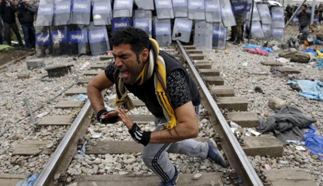 Seorang imigran saat terlibat bentrokan dengan polisi Makedonia, Desa Idomeni, Yunani (28/11/2015). (REUTERS/Yannis Behrakis)