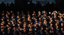 Para suporter tampak silau saat menyaksikan laga Liga Inggris antara Everton melawan Southampton di Stadion Goodison Park, Inggris, Senin (2/1/2017). Everton menang 3-0 atas Southampton. (AFP/Paul Ellis)
