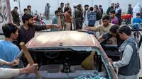 Warga membersihkan mobil yang rusak akibat ledakan,bom di restoran Kabul, Afghanistan, Rabu, 21 September 2022. (AP)
