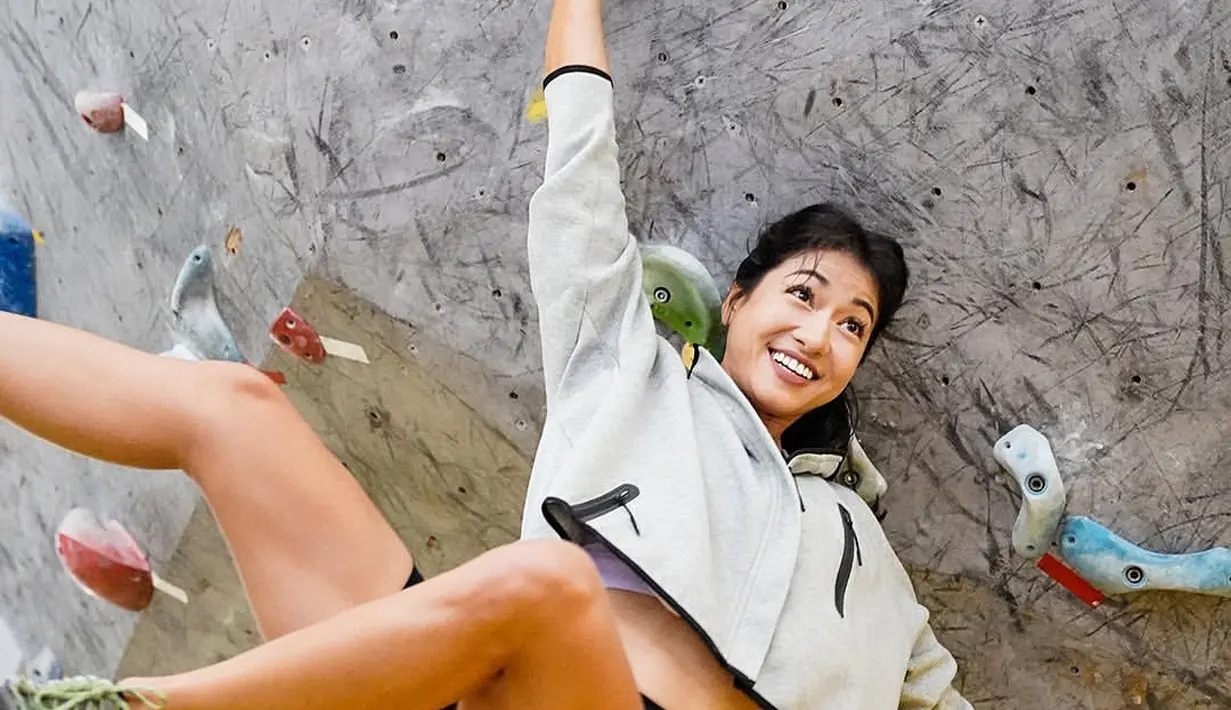 Wall climbing juga menjadi olahraga yang digemarinya. Ia tampak mengenakan jaket dan bicycle pants.