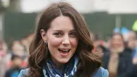 Kate Middleton tersenyum semringah usai menerima hadiah bunga dari anak-anak saat mengunjungi Roe Green Junior School di London, Inggris, Selasa (23/1). Kunjungan sekaligus peluncuran program kesehatan mental untuk anak-anak. (Jonathan Brady/POOL /AFP)