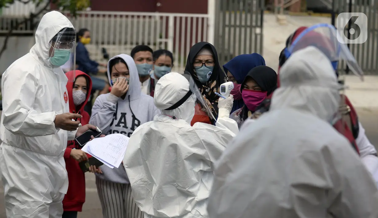 Petugas Puskesmas memeriksa suhu warga yang mengikuti swab test di Balai RW 20, Villa Dago, Pamulang, Tangerang Selatan, Banten, Jumat (17/7/2020). Swab test gratis yang digelar seiring meningkatnya kasus COVID-19 tersebut diikuti 200 warga dari beberapa RW di Benda Baru. (merdeka.com/Dwi Narwoko)