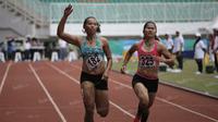 Atlet Jawa Timur, Tri Setyo Utami (kiri), meraih emas lari 100m putri PON XIX Jawa Barat 2016 setelah mengalahkan atlet Sumatra Barat, Lusiana Satriani (kanan) dalam final di Stadion Pakansari, Bogor, Kamis (22/9/2016). (Bola.com/Arief Bagus)
