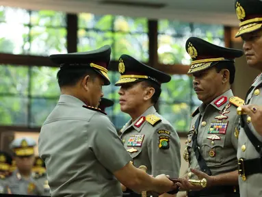 Kapolri Jenderal Tito Karnavian menyerahkan tongkat komando kepada Irjen Idham Aziz dalam acara sertijab di Rupatama Mabes Polri, Rabu (26/7). Idham Aziz resmi menjabat Kapolda Metro Jaya menggantikan Irjen Mochamad Iriawan (Liputan6.com/Faizal Fanani)
