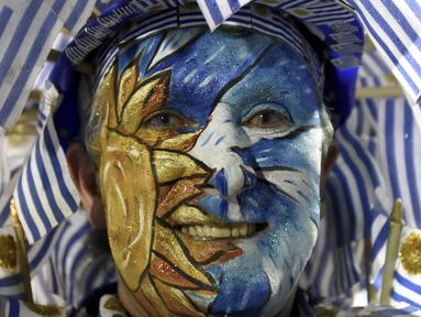 Salah satu pendukung timnas Uruguay mewarnai wajahnya dengan bendera negaranya saat mendukung timnya melawan Argentina pada laga kualifikasi Piala Dunia 2018 di Montevideo, Uruguay, (31/8/2017). Argentina imbang 0-0 lawan uruguay. (AP/Matilde Campodonico)