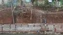 Pekerja membangun turap di bantaran Kali Cijantung, Jakarta Timur, Kamis (11/10). Pembangunan turap bertujuan mencegah longsor yang dapat membahayakan warga sekitar. (Liputan6.com/Immanuel Antonius)