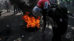 Sebuah ban dibakar saat aksi di depan Istana Presiden, Jakarta, Rabu (20/5/2015). Ribuan mahasiswa menuntut agar Jokowi - JK segera turun. (Liputan6.com/Johan Tallo)