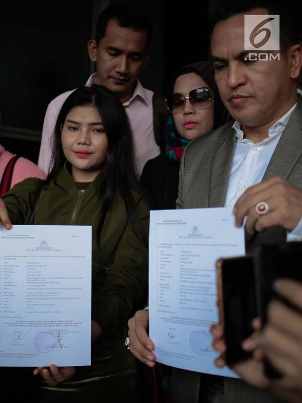 Rosa Meldianti didampingi kuasa hukumnya menunjukkan surat laporan di Polda Metro Jaya, Jakarta, Selasa (6/11). Meldi melaporkan balik pedangdut yang juga tantenya, Dewi Perssik atas tuduhan melakukan pencemaran nama baik. (Liputan6.com/Faizal Fanani)