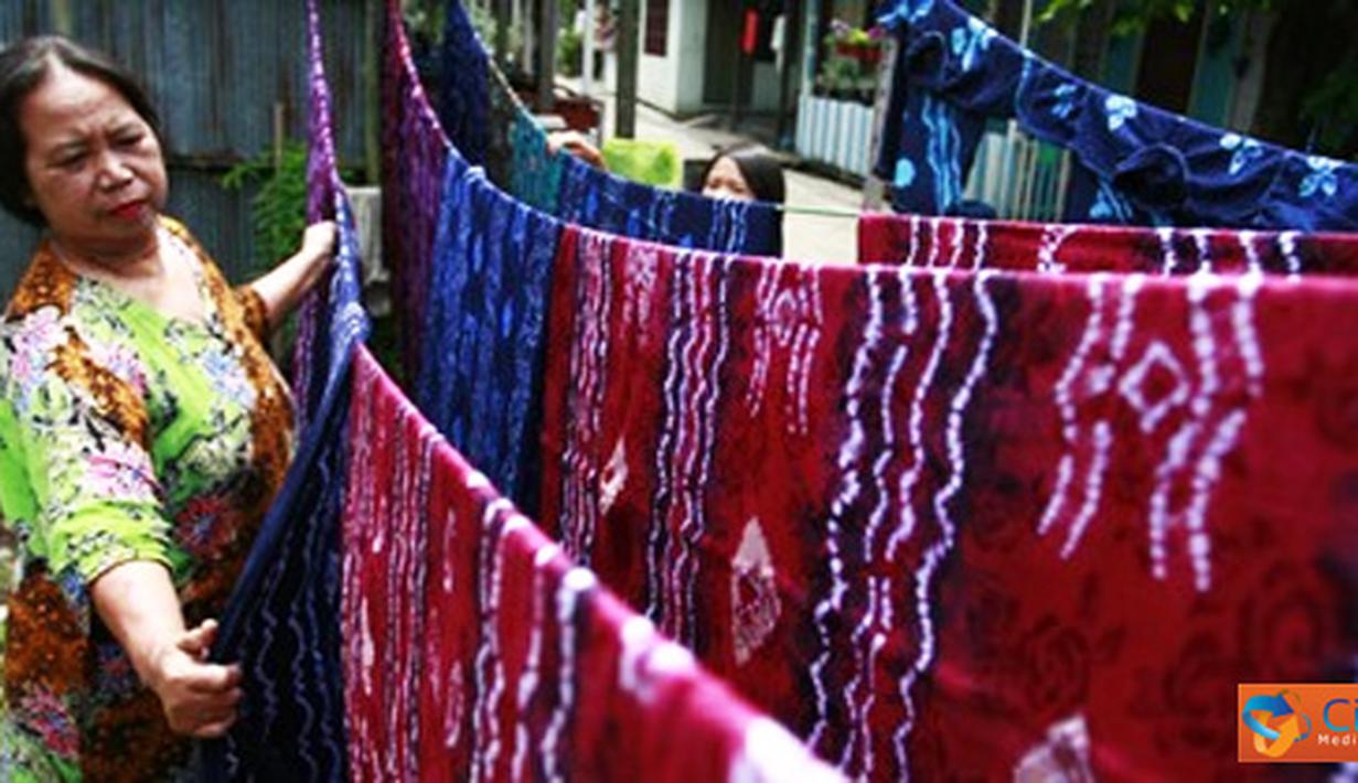 Citizen6, Banjarmasin: Seorang pengrajin menjemur kain sasirangan yang selesai diwarnai.