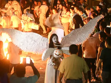Sejumlah peserta mengenakan kostum hantu menggelar pawai dalam parade La Calabiuza di Tonacatepeque, El Salvador (1/11). Parade tersebut untuk memperingati Hari Orang Mati. (AFP Photo/Marvin Recinos)
