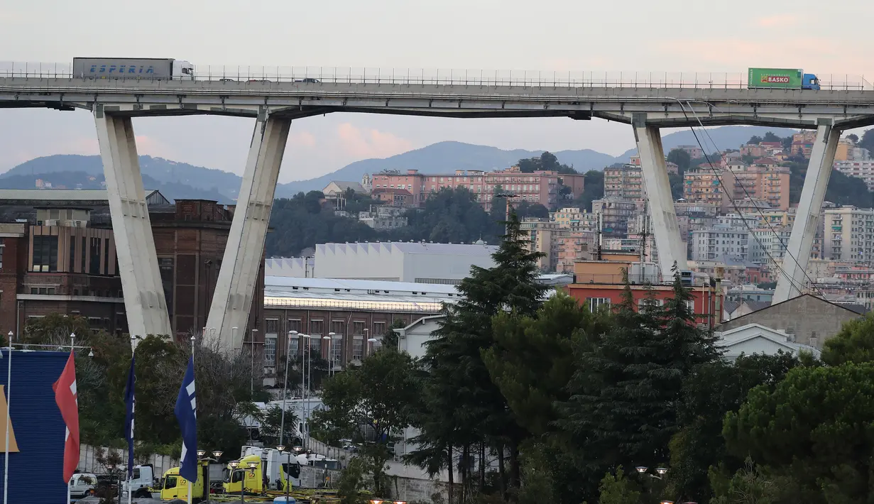 Sebuah truk berada di atas jembatan Morandi, dekat dengan bagian jalan layang yang runtuh, di Genoa, italia, Selasa (14/8). Insiden ini disebut sebagai peristiwa jembatan ambruk paling mematikan di Eropa sejak 2001. (ANDREA LEONI/AFP)