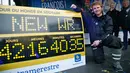 Pelaut Prancis, Francois Gabart (34) berpose dengan papan rekor dunianya di pelabuhan Brest, Minggu (17/12). Gabart memecahkan rekor berlayar mengelilingi dunia sendirian dalam waktu 42 hari, 16 jam, 50 menit dan 35 detik. (AP/Thibault Camus)