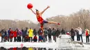 Seorang perenang musim dingin yang mengenakan kostum menyelam ke dalam danau yang sebagian membeku di Shenyang, provinsi Liaoning, China, Selasa (19/2). Mereka percaya berendam di sungai dengan suhu yang ekstrem baik untuk kesehatan. (Photo by STR / AFP)