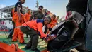 Distribusi ini dilakukan melalui jalur laut, dan udara, mengingat banyak akses jalan yang terputus. Tampak dalam foto, para relawan menurunkan bantuan untuk korban banjir bandang di permukiman warga Banda Aceh, Provinsi Aceh, pada 1 Desember 2025. (Chaideer MAHYUDDIN/AFP)