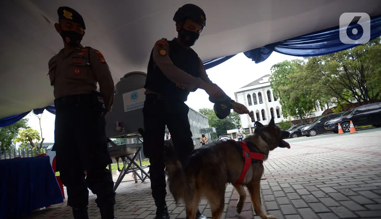 Polisi dan anjing berjaga di area Gereja Katedral, Jakarta, Jumat (24/12/2021). Sebanyak 100 personel diturunkan untuk mengamankan ibadah Natal 2021 di Gereja Katedral. (merdeka.com/Imam Buhori)
