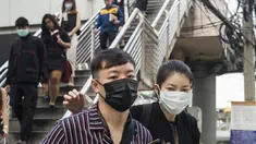 Pekerja mengenakan masker usai menaiki komuter selama kabut asap menyelimuti Bangkok (16/1). Thailand telah berupaya untuk mengatasi polusi yang telah menyelimuti ibukota dalam beberapa pekan terakhir. (AFP Photo/Romeo Gacad)