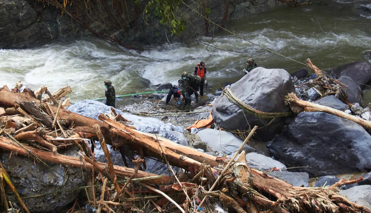 Hingga Senin (1/12/2025), tim gabungan terus melakukan upaya pencarian dan penyelamatan korban banjir yang melanda sejumlah wilayah di Aceh, Sumatera Utara, dan Sumatera Barat. Tampak dalam foto, tim penyelamat mencari korban banjir di Tanah Datar, Sumatera Barat, Senin 1 Desember 2025. (AP Photo/Nazar Chaniago)