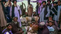 Penjual opium dan pembeli mengobrol tentang teh hijau di sekitar karung opium dan hashish di sebuah pasar opium di Kandahar, Afghanistan (BULENT KILIC / AFP)