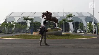 Pewarta melihat-lihat di salah satu pintu masuk kawasan Jakarta International Equestrian Park Pulomas, Jakarta, Kamis (2/8). JIEPP akan menjadi venue tiga cabang equestrian Asian Games 2018. (Liputan6.com/Helmi Fithriansyah)