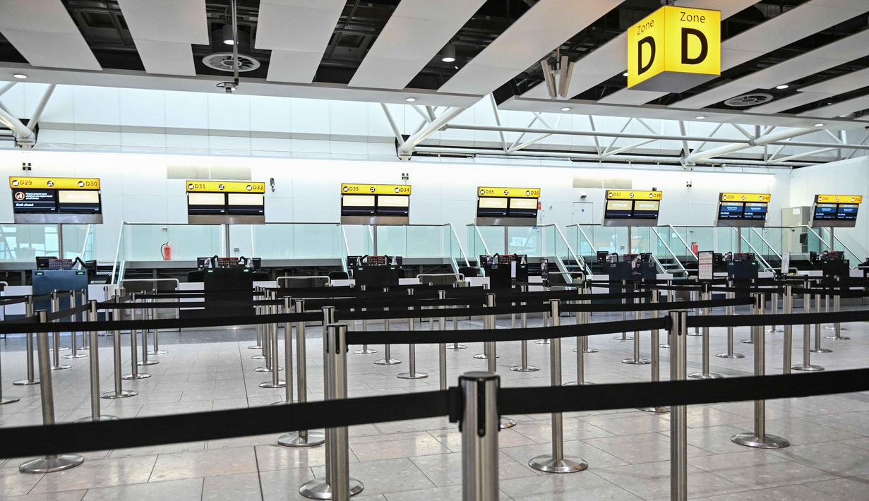 Penutupan ini imbas serangan yang diluncurkan Amerika Serikat dan Israel terhadap Iran pada Sabtu (28/2/2026) pagi. Tampak dalam foto, meja-meja kosong terlihat di konter check-in maskapai penerbangan Etihad di Bandara Heathrow, London pada Minggu 1 Maret 2026. (JUSTIN TALLIS/AFP)