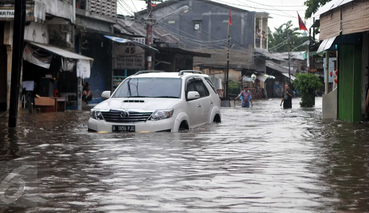 Sebuah mobil menerobos banjir di kawasan Pasar Buncit, Jakarta Selatan, Selasa (9/2/2016). Banjir menggenangi kawasan tersebut hingga setinggi 100 cm akibat luapan Kali Kemang. (Liputan6.com/Gempur M Surya)