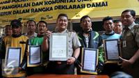 Petugas kepolisian bersama pengemudi ojek online dan ojek pangkalan memperlihatkan deklarasi damai komunitas ojek pangkalan dengan komunitas ojek online di Polsek Kebun Jeruk, Jakarta (22/9/2015). (Liputan6.com/Gempur M Surya)